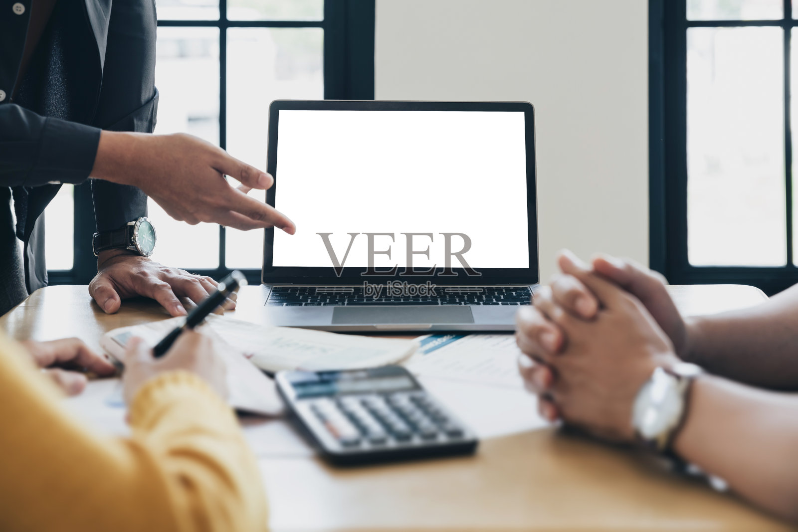 商务人士在会议上使用笔记本电脑讨论公司的未来结构。照片摄影图片