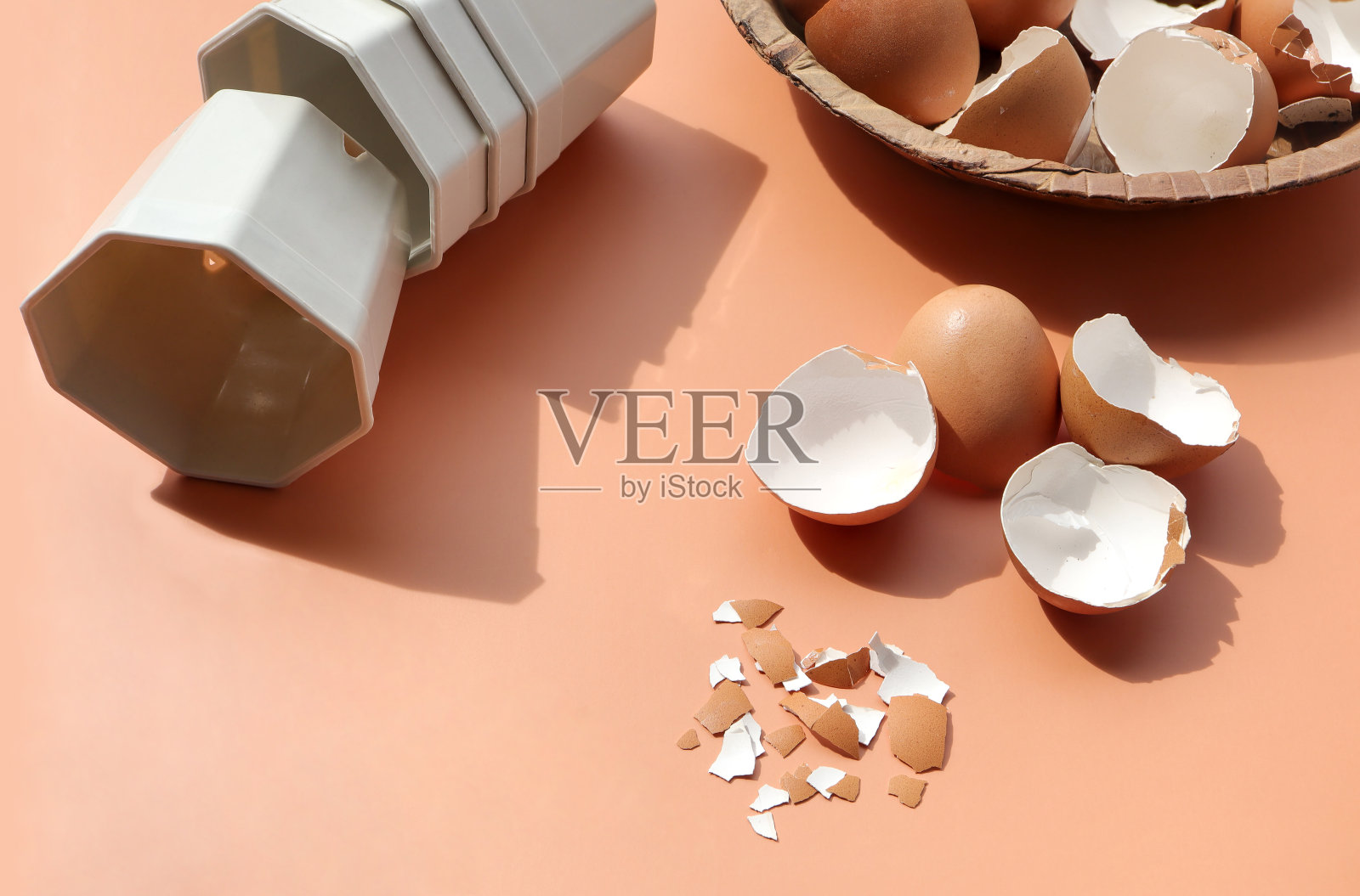 米色背景上的一组破蛋壳和空塑料花盆。回收厨房垃圾，粉碎的蛋壳用于堆肥和花园。照片摄影图片