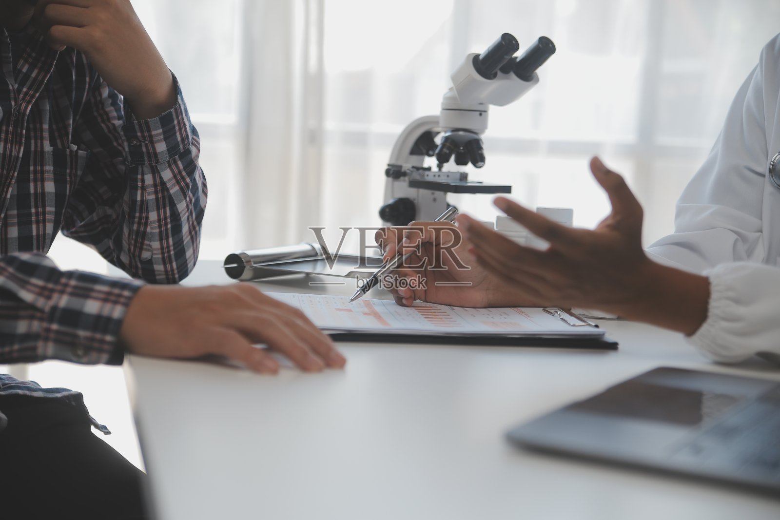 专业实验室。令人惊叹的长发医务工作者穿着制服，在研究中使用显微镜照片摄影图片