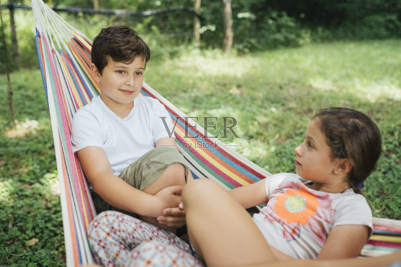 孩子们一起在吊床上聊天，玩得很开心照片摄影图片