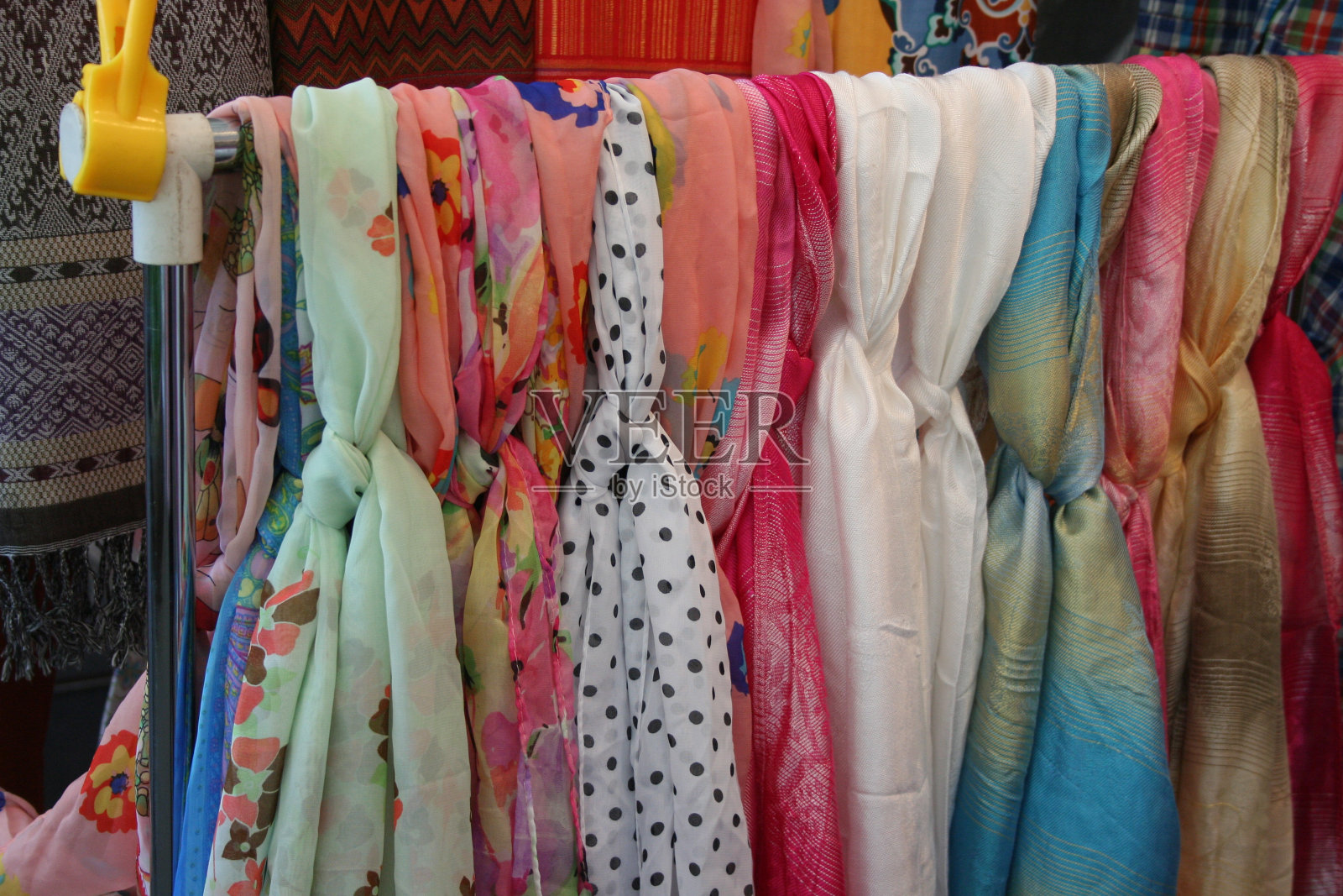 纪念品市场上彩色围巾的特写。照片摄影图片