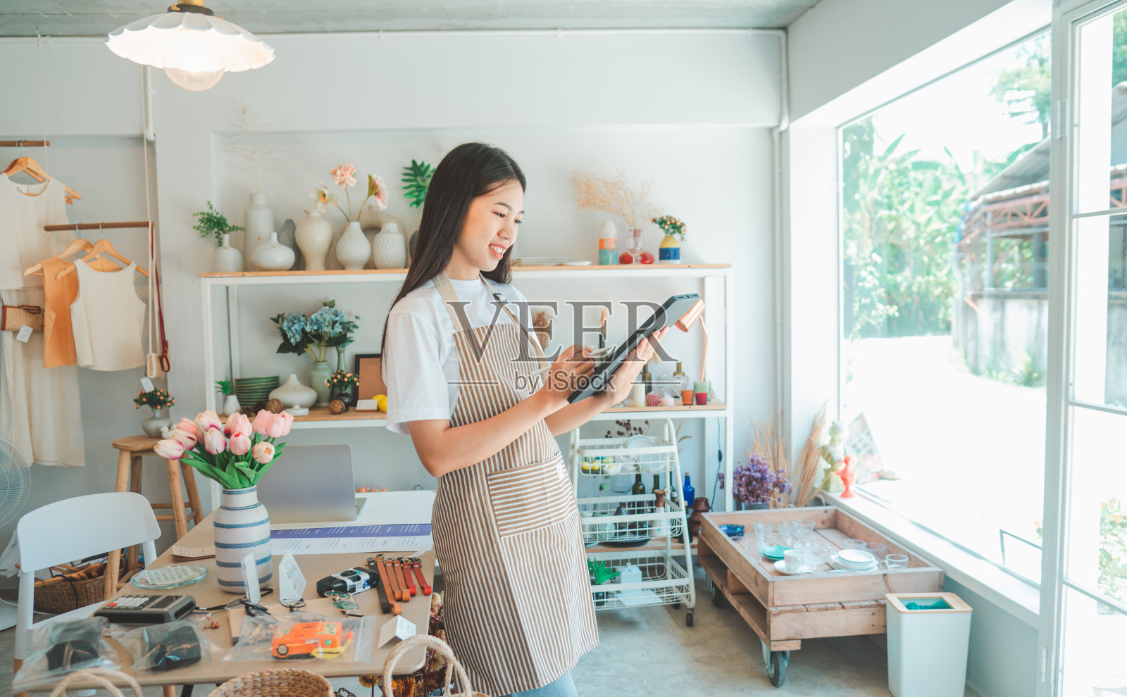 小企业主正在准备一个小商店，并通过平板电脑检查和检查订单。照片摄影图片