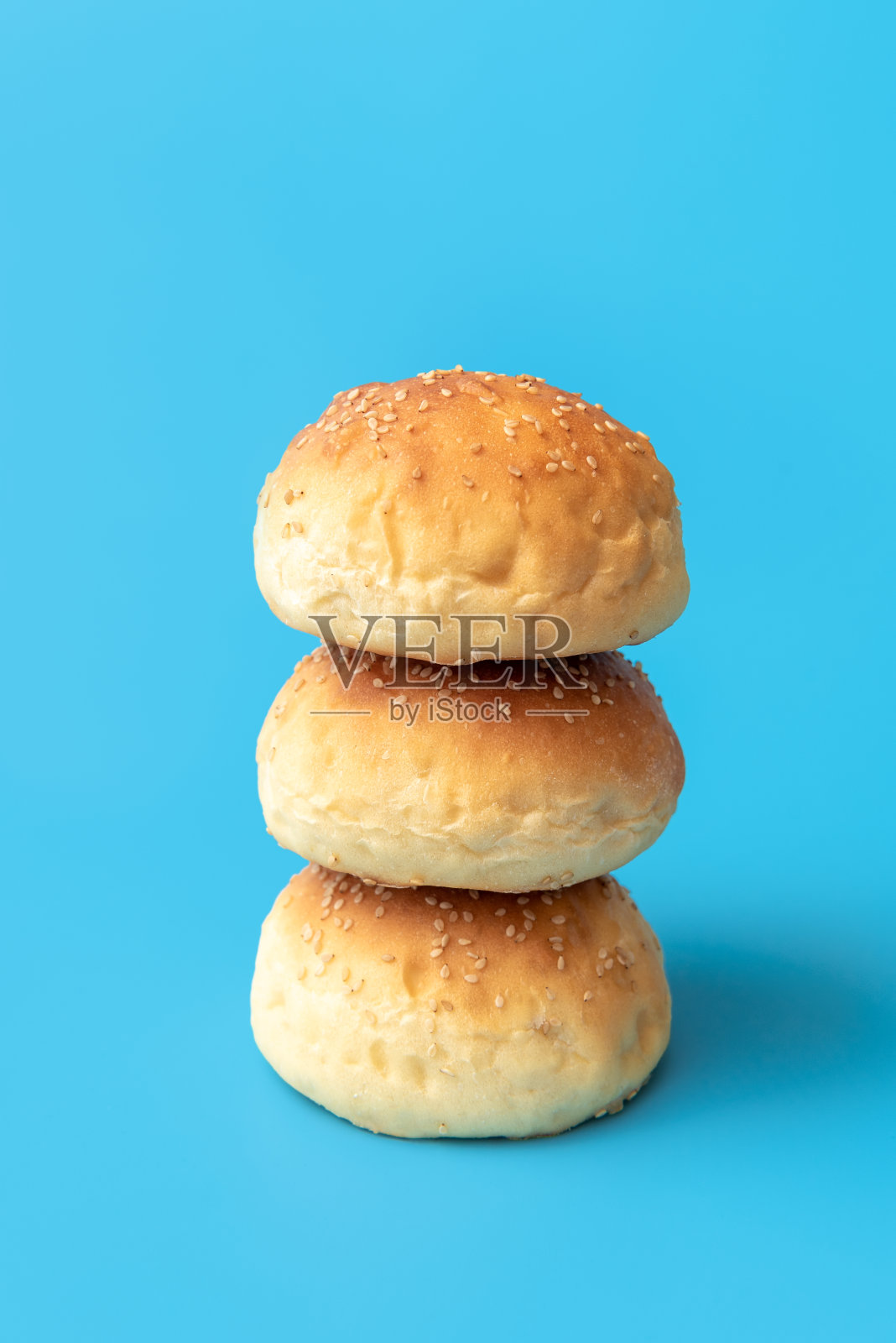 汉堡面包被隔离在蓝色背景上。自制小面包照片摄影图片