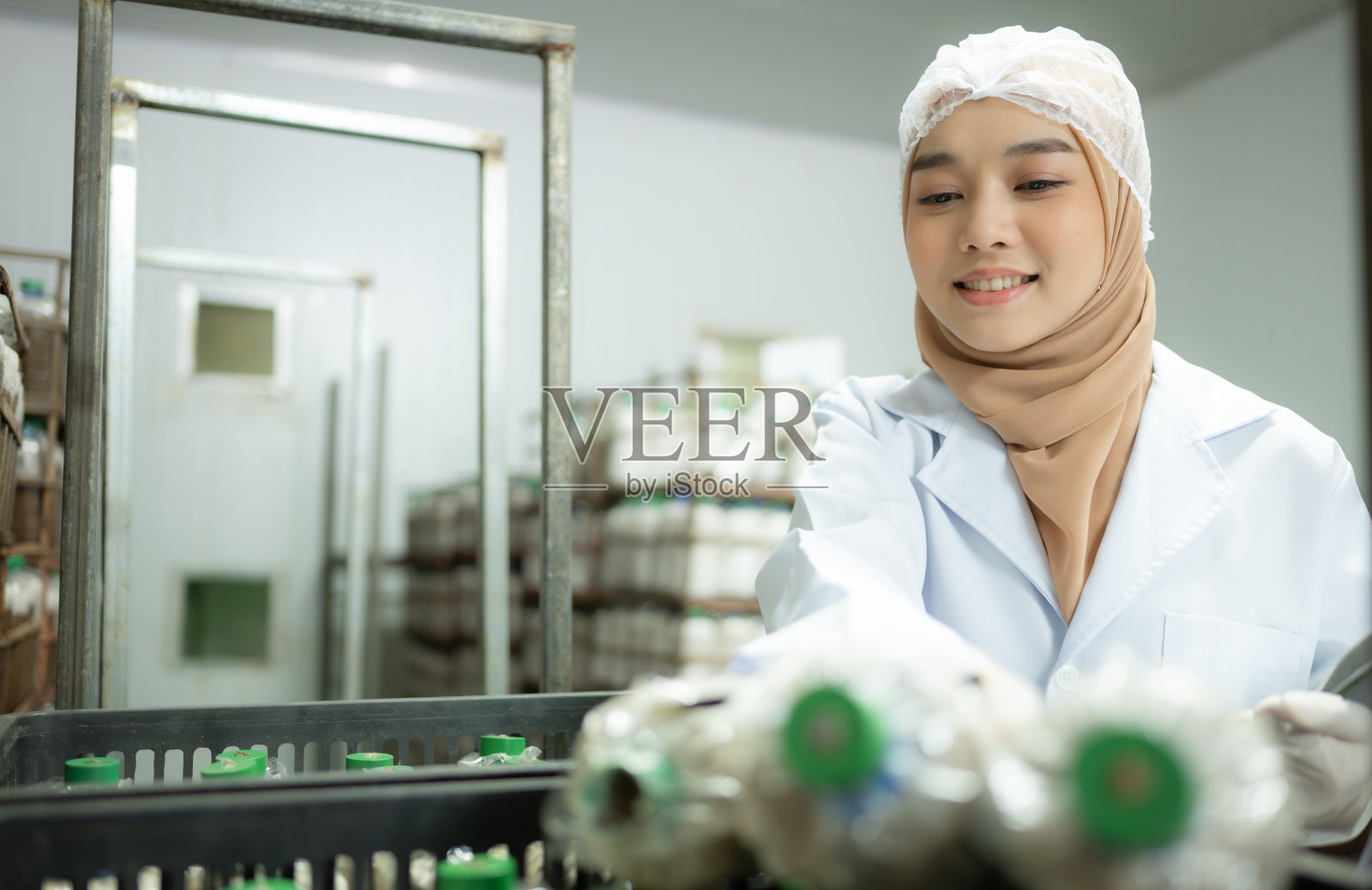 年轻的亚洲穆斯林女科学家在蘑菇工厂做研究，在无菌温控的房间里检查蘑菇发酵剂。照片摄影图片