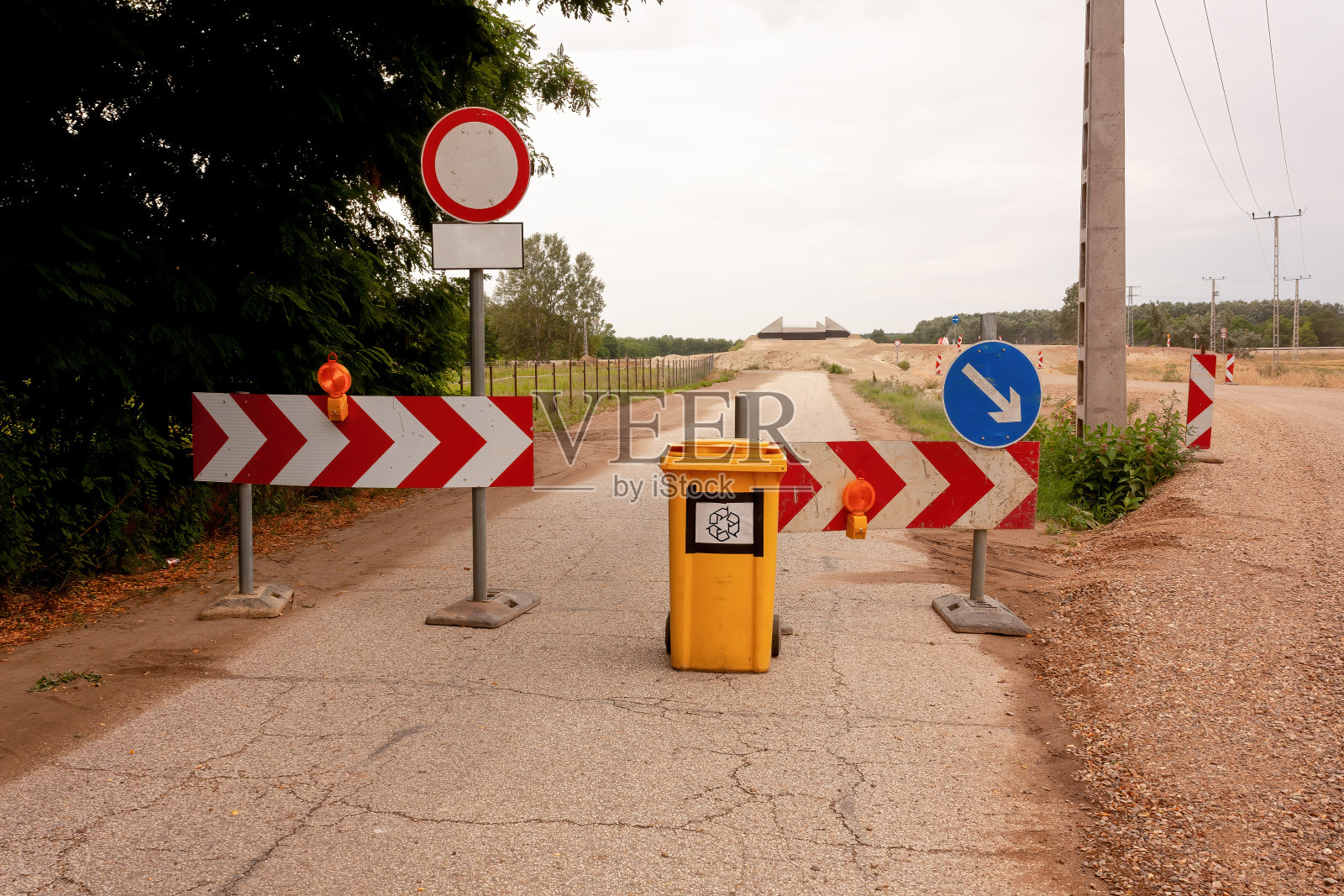 建筑工地的黄色垃圾桶，上面有回收标志。照片摄影图片