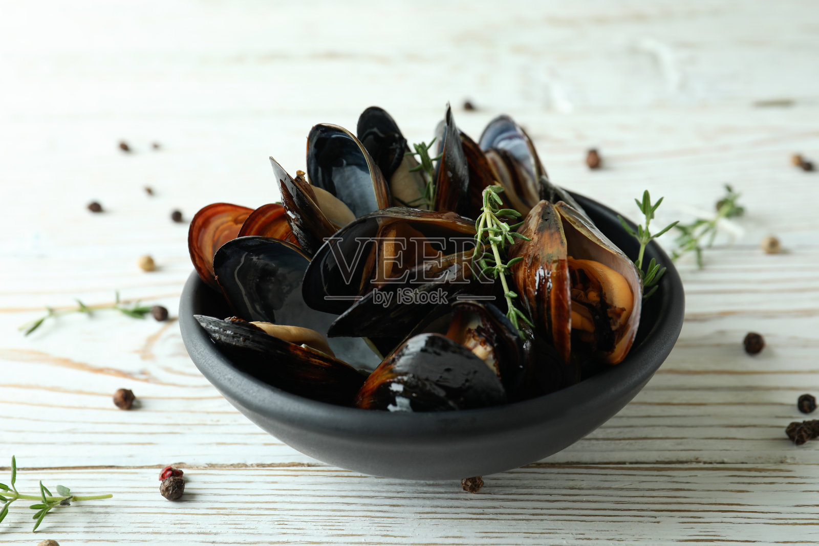 白色木桌上盛着新鲜贻贝的碗照片摄影图片