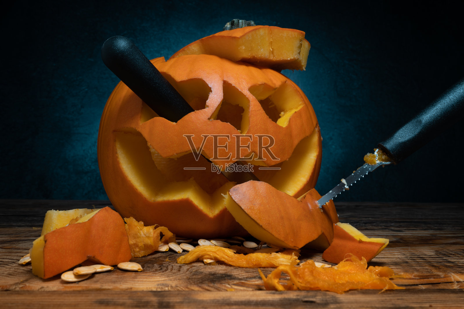 万圣节雕刻南瓜和雕刻工具集，为南瓜灯的脸剪出来。照片摄影图片