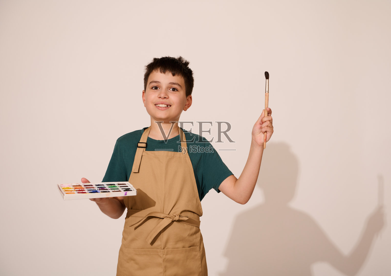 可爱的男童享受美术课，指着画笔和水彩调色板照片摄影图片