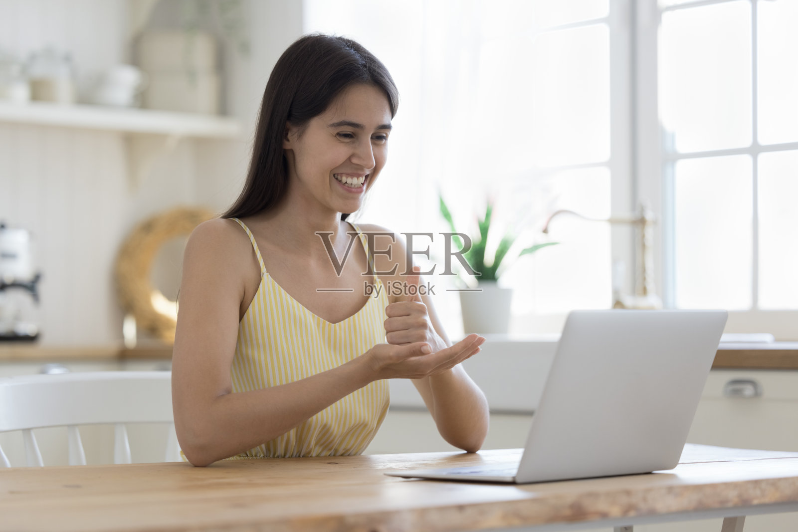 开朗的西班牙女孩用笔记本电脑进行视频通话照片摄影图片