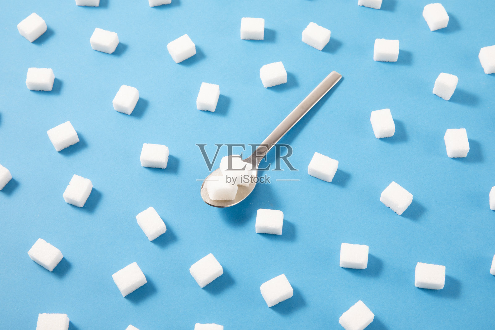 蓝色背景上的白糖块照片摄影图片