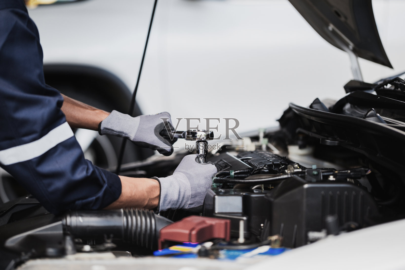 专业的机械师正在车库里修理汽车的发动机。汽车修理服务。照片摄影图片