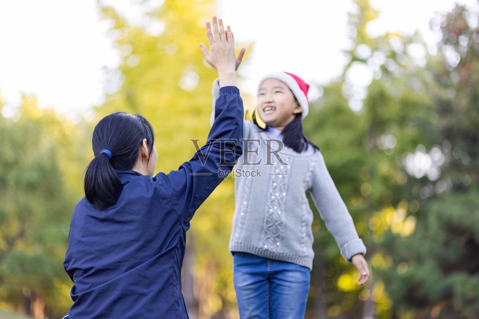 妈妈和圣诞女孩击掌照片摄影图片