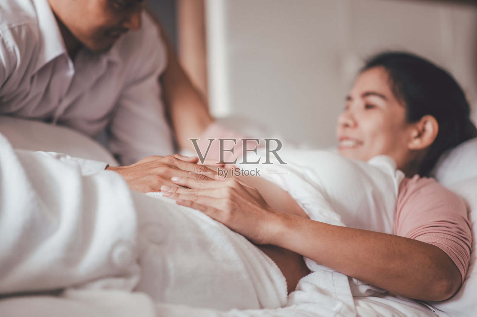 亚洲女人和丈夫抚摸女友的肚子，感觉婴儿的动作。照片摄影图片