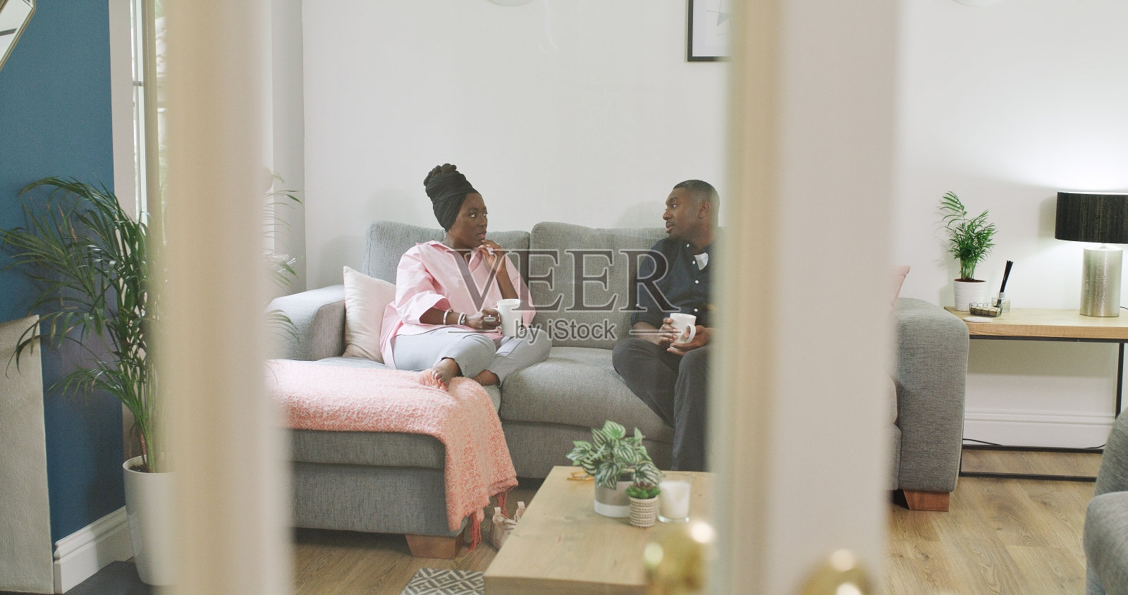 爱，家和黑夫妇坐在沙发上，喝咖啡和聊天，互相支持，相爱在一起放松。婚姻，男人或女人坐在沙发上，喝茶或小心地说话，浪漫和亲密的高质量时间照片摄影图片