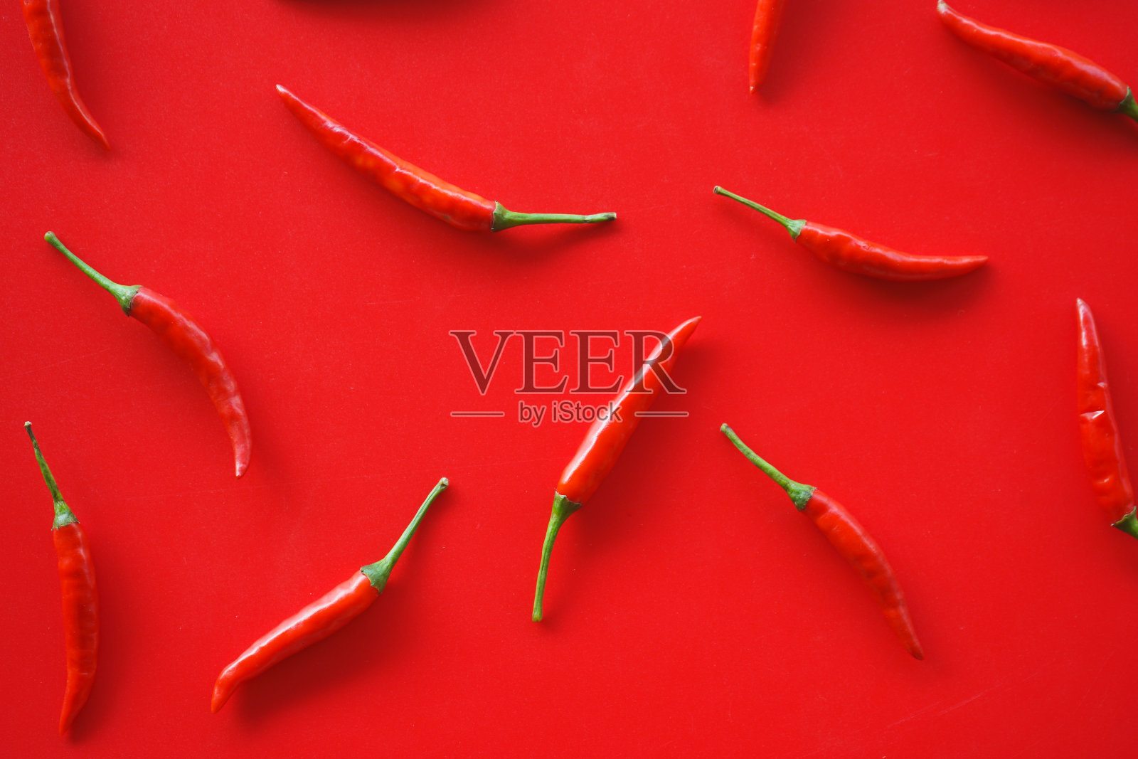 红辣椒排列在红色的背景上照片摄影图片