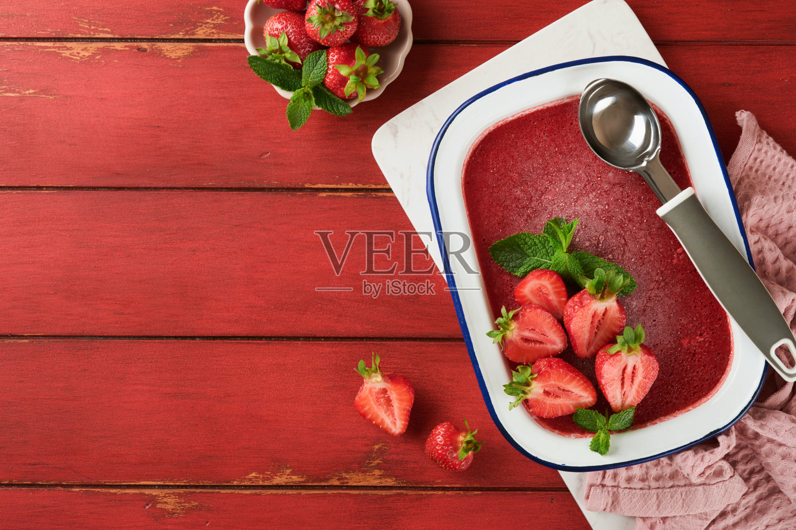 草莓格兰尼塔或新鲜的浆果冰沙在白色质朴的碗在旧木桌背景。草莓和薄荷冰淇淋。夏天治疗。前视图。照片摄影图片