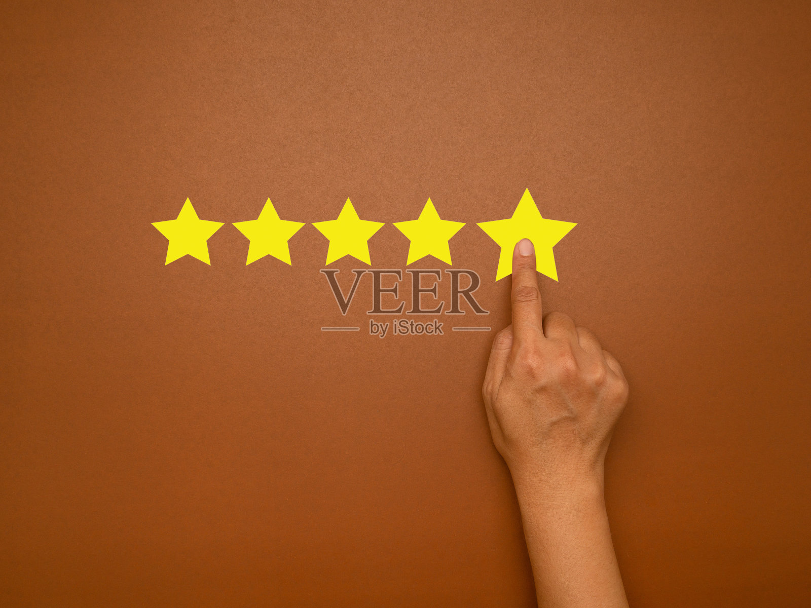 在棕色背景上，手压五星优秀评级的俯视图照片摄影图片