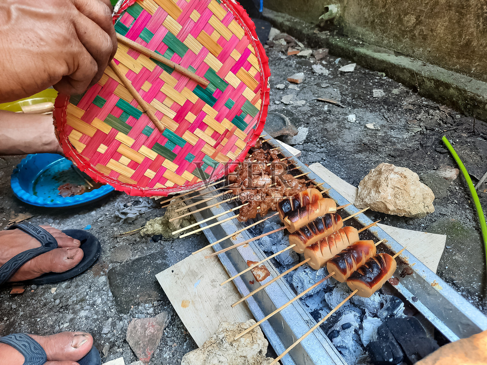 有人在木炭烤炉上烤烤牛肉沙爹和烤香肠(Sate Daging Sapi Dan Sosis Tusuk)照片摄影图片