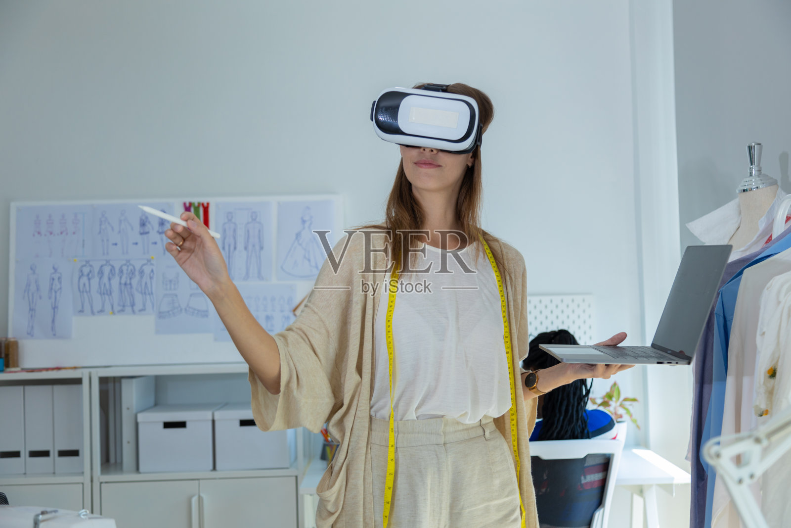 年轻的设计师们正在为小型裁缝企业设计夏季时装照片摄影图片