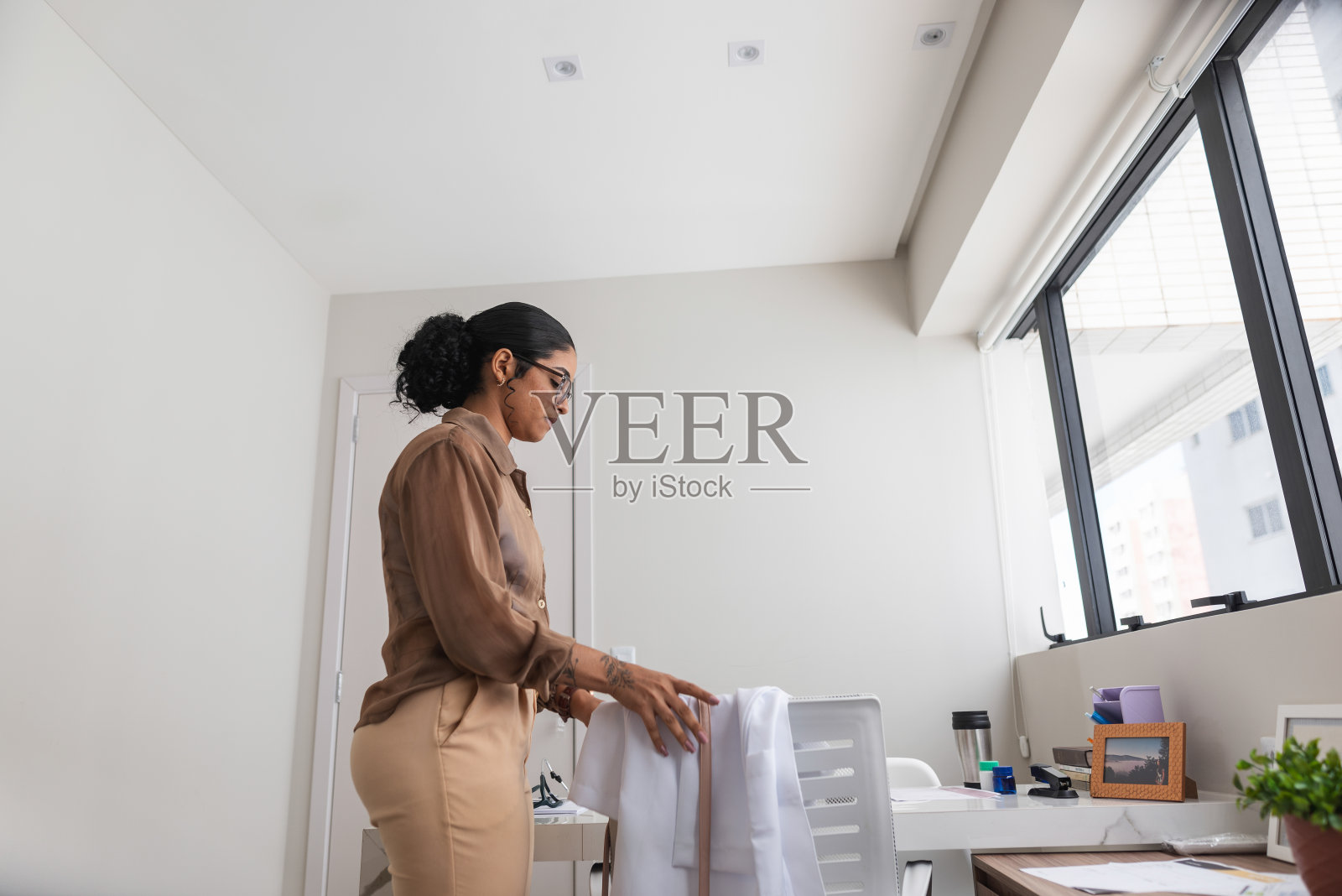 年轻的女医生来到她的办公室照片摄影图片