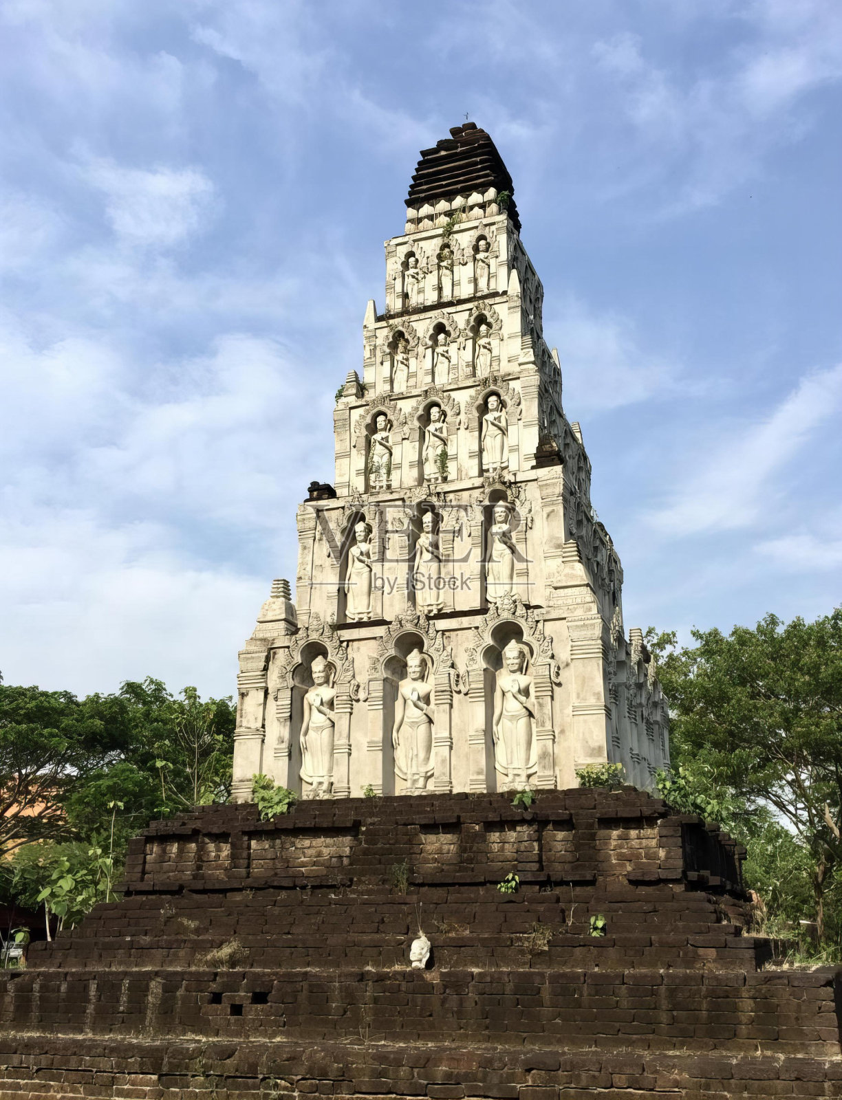 一个高塔上有雕像的照片，一个公园里的高塔上有雕像。照片摄影图片