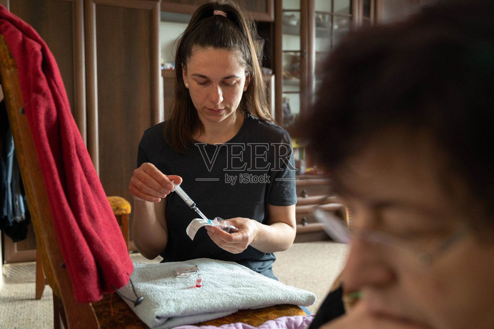 护士从包装里拿出一个新的注射器。照片摄影图片