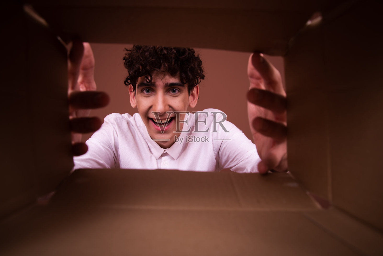 在棕色背景上摆着不同的情感和天赋的年轻有趣的家伙。照片摄影图片