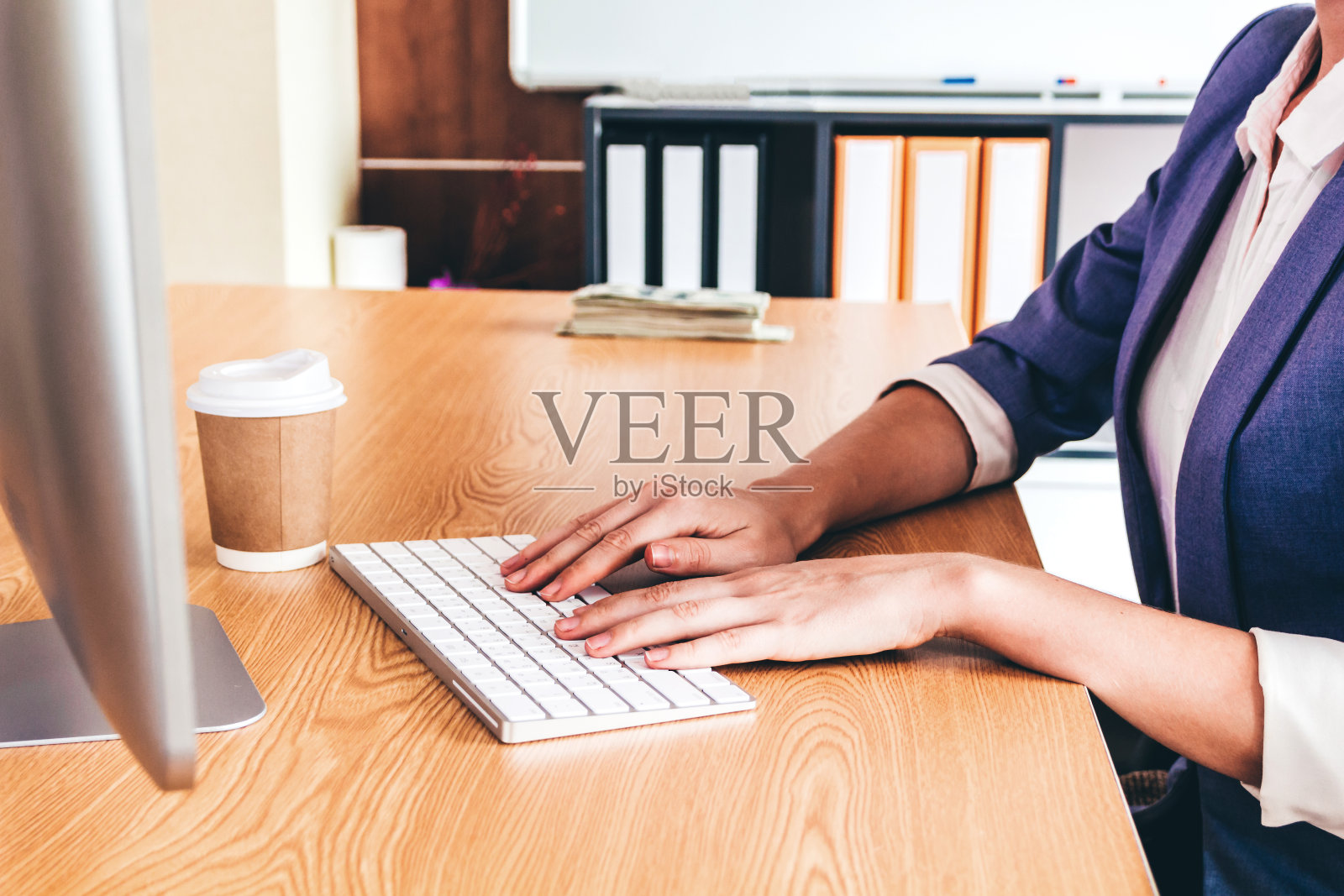 现代办公室里使用电脑并在键盘上打字的女商人照片摄影图片