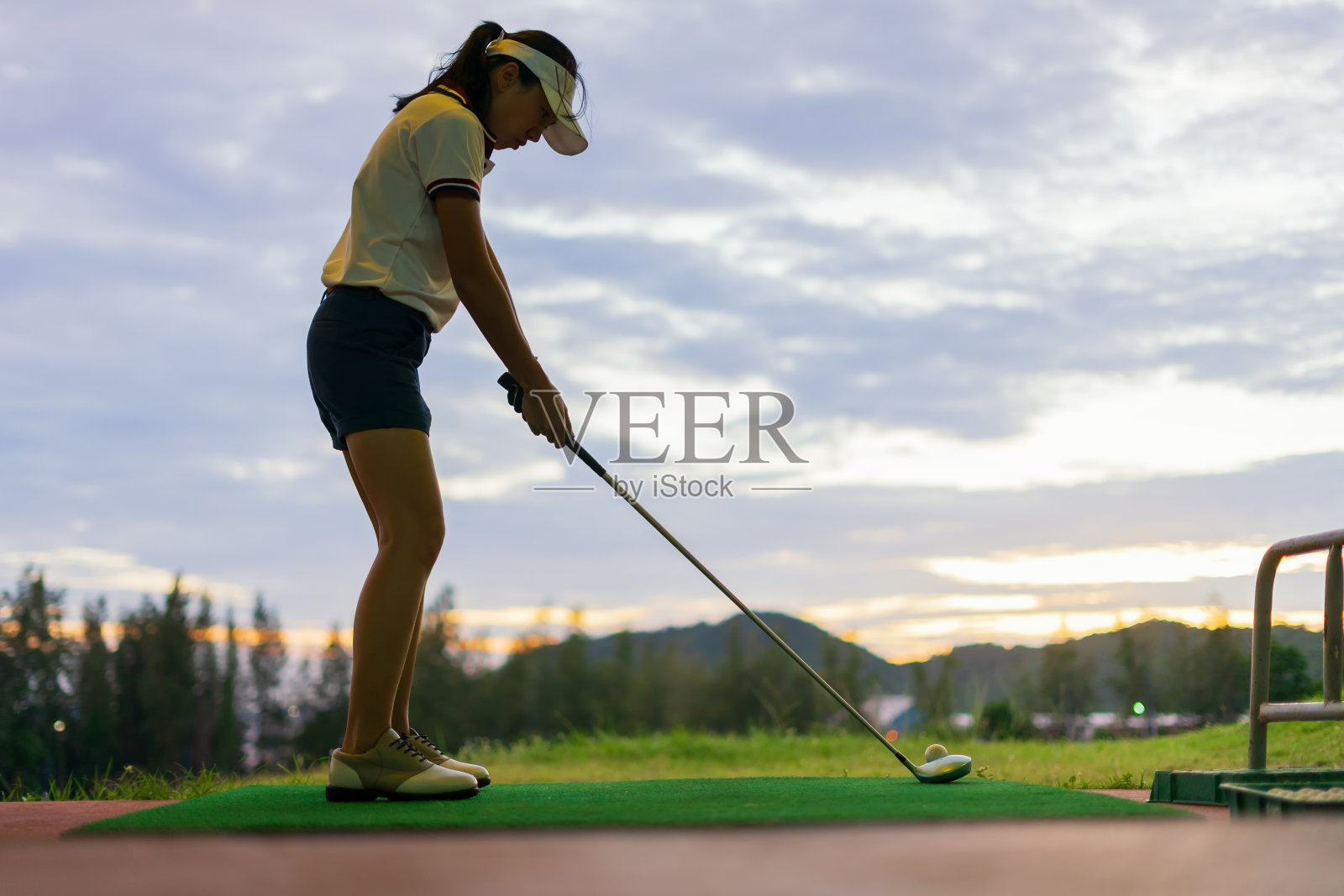 绿草地上的高尔夫球，准备在高尔夫球杆上击球照片摄影图片