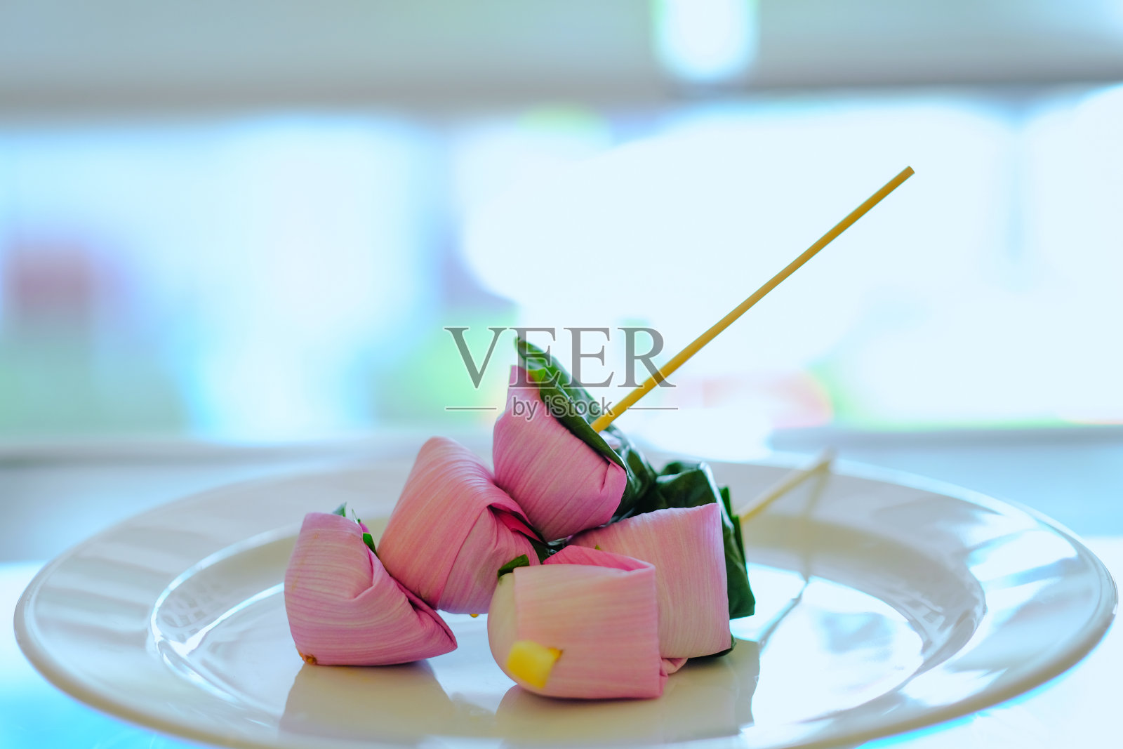 香康是一种泰国草药小吃，荷叶包开胃菜与辣椒在白色碟子上，泰国草药小吃具有药用特性。照片摄影图片