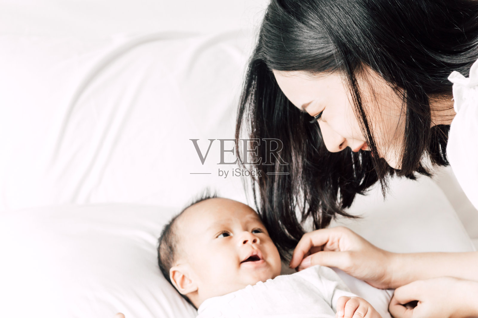 妈妈在家里的床上和宝宝玩耍的照片照片摄影图片