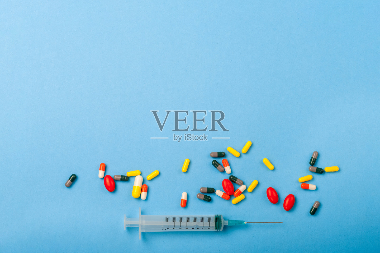 蓝色背景的药品和一次性注射器特写。保健药学药理学概念照片摄影图片