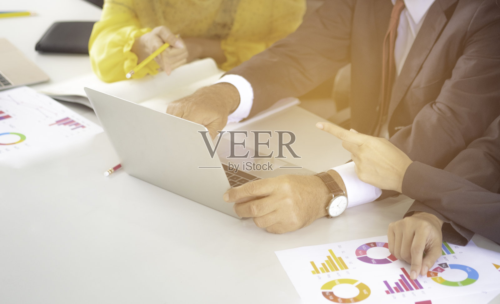 阿拉伯商业理念，阿拉伯商人。年轻的女商人正在与白人商人和亚洲女商人交谈，并指着笔记本电脑建议或帮助工作规则。照片摄影图片