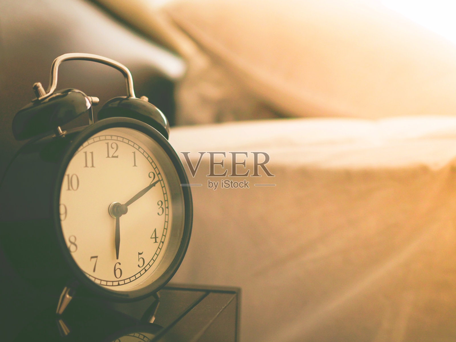 闹钟在卧室的床上照片摄影图片