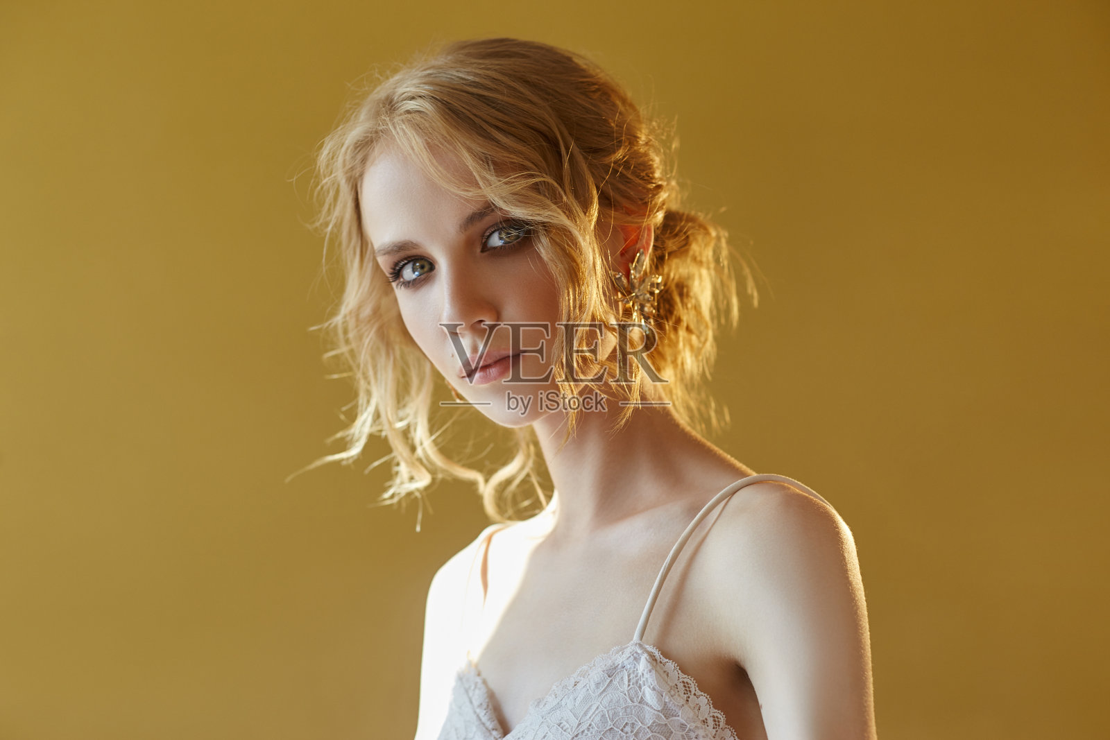 耳环和珠宝在一个性感的金发女人的耳朵压。完美的金发女孩，华丽神秘的外表。广告珠宝，美丽的耳环戴在女孩的耳朵里。本空间照片摄影图片