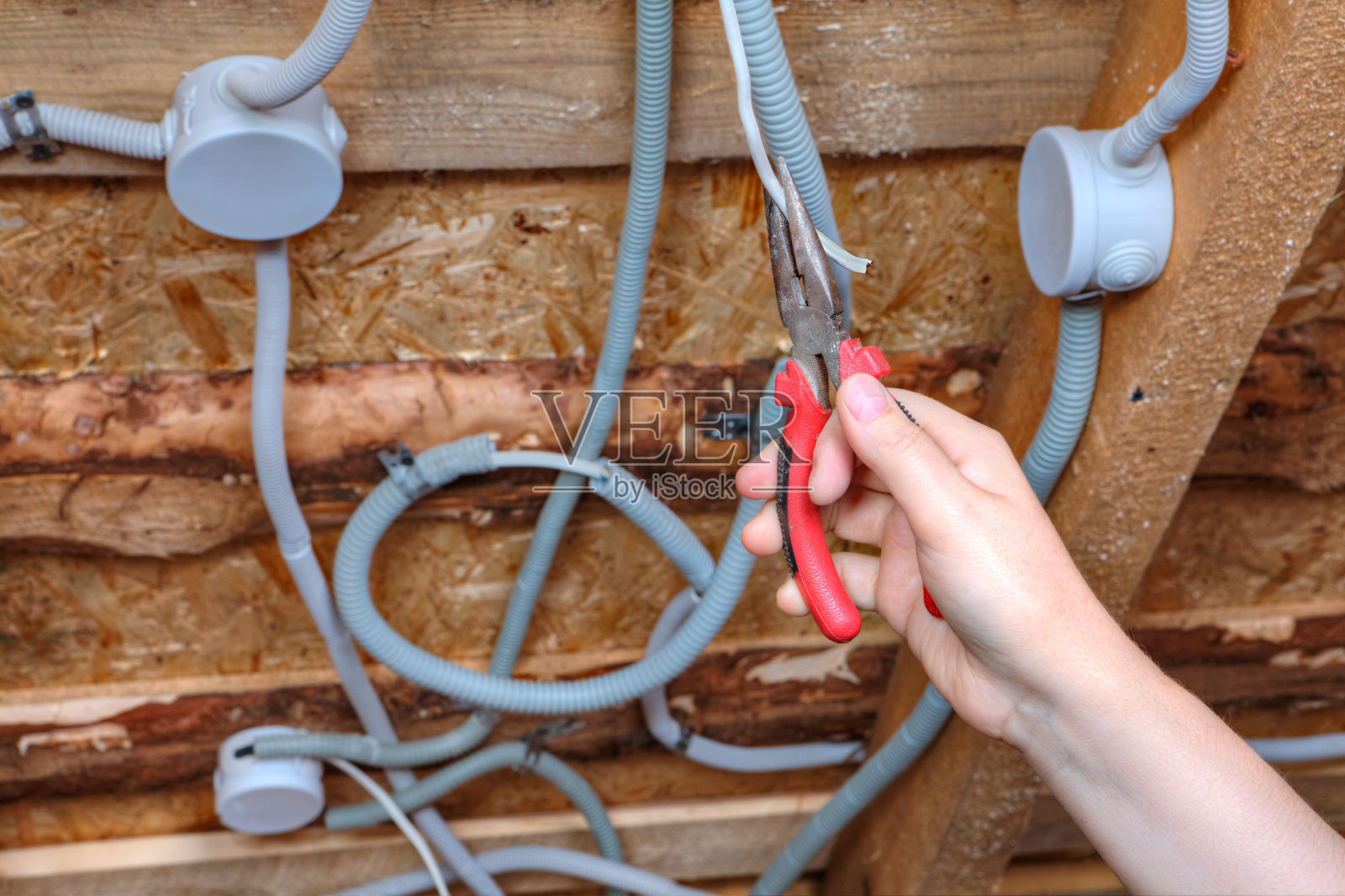 安装顶灯线路，电工用钳子手安装。照片摄影图片