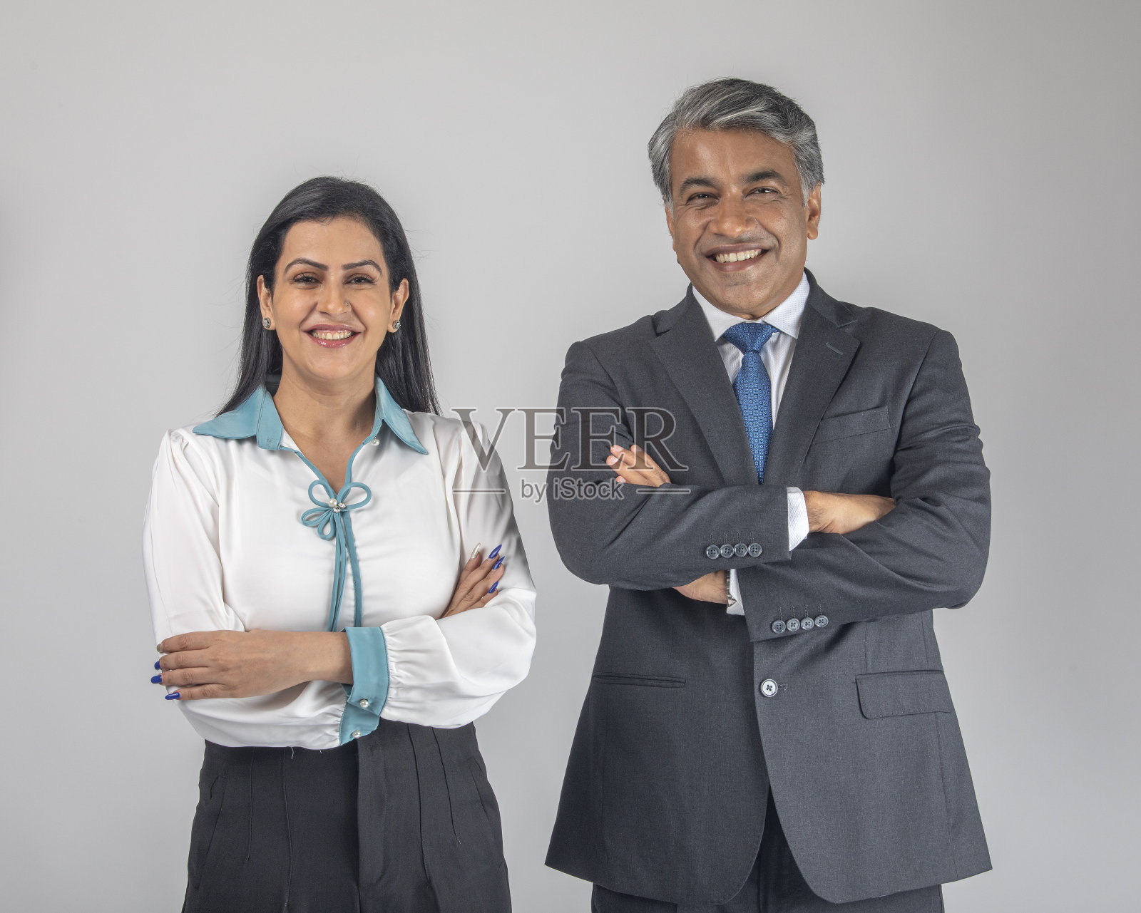 同事们面带微笑，双手交叉站在白色背景上照片摄影图片