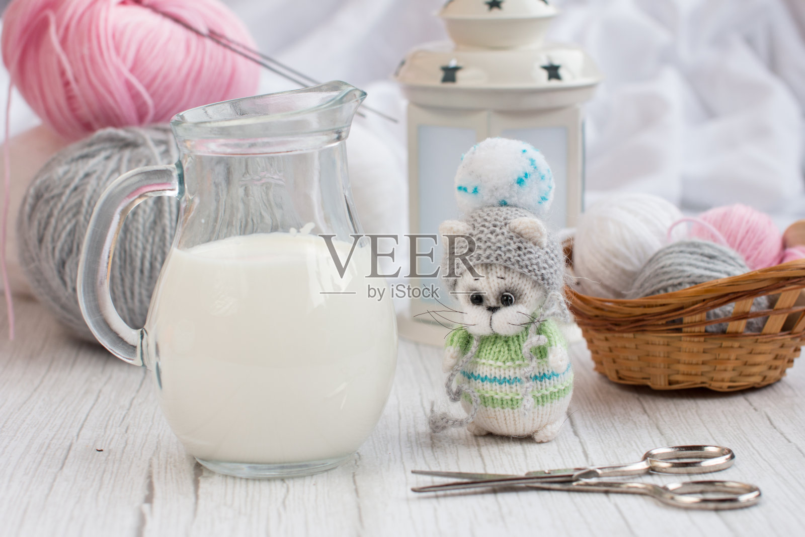 一只用编织针编织的小猫，篮子里有彩色的线球。手工刺绣创意工作坊照片摄影图片