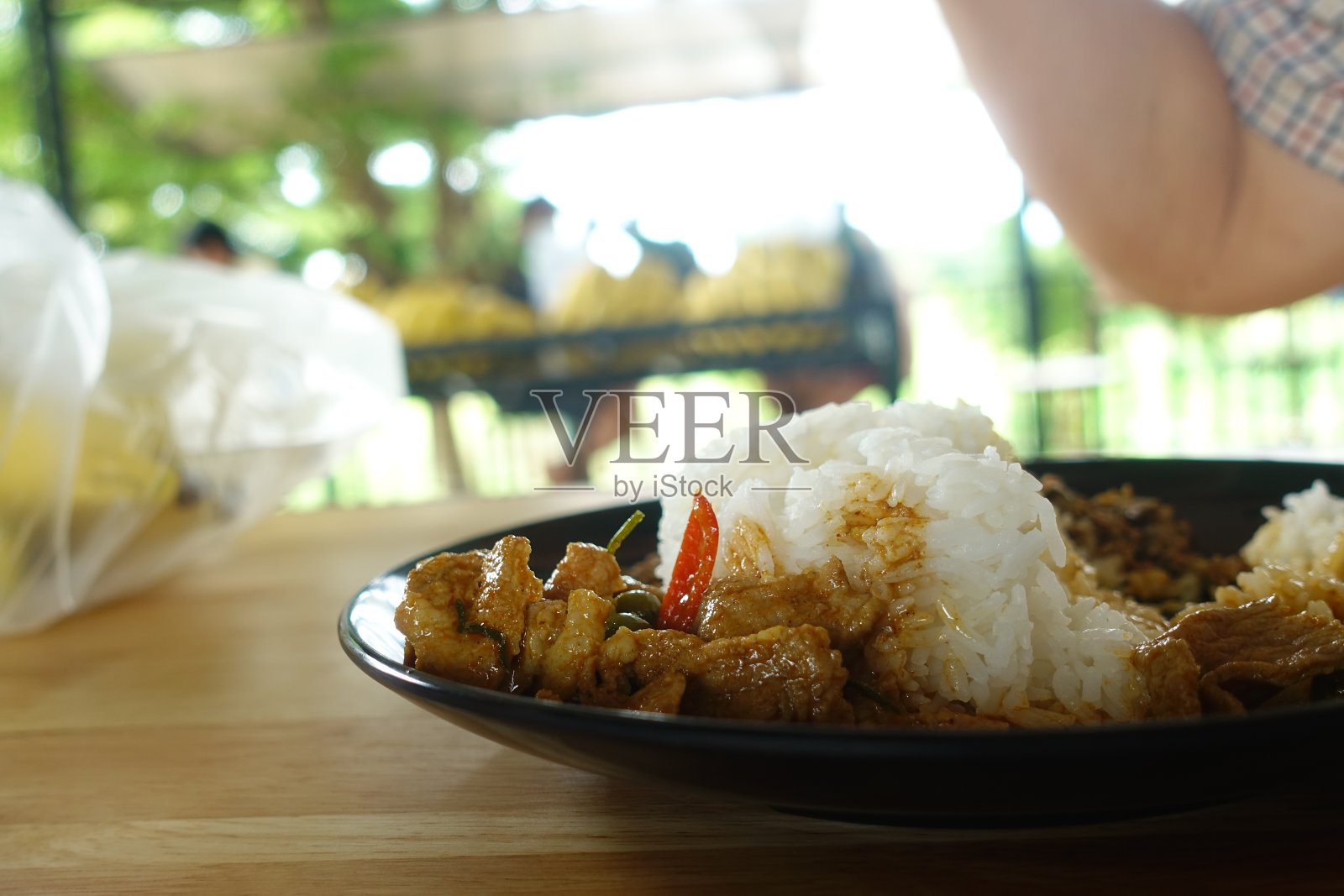 鸡肉咖喱(Panang Kai)的食谱与茉莉米在黑色盘子木桌上。泰国菜咖喱配花生、椰子和肉。泰式快餐照片摄影图片