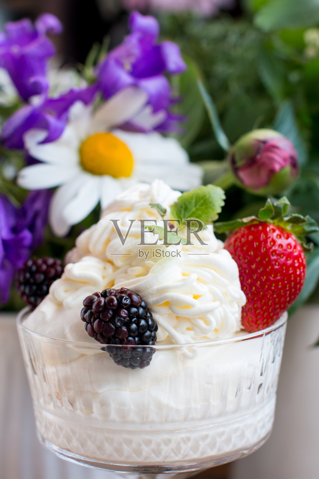 玻璃杯里的鲜奶油加浆果。有草莓和黑莓的甜点照片摄影图片