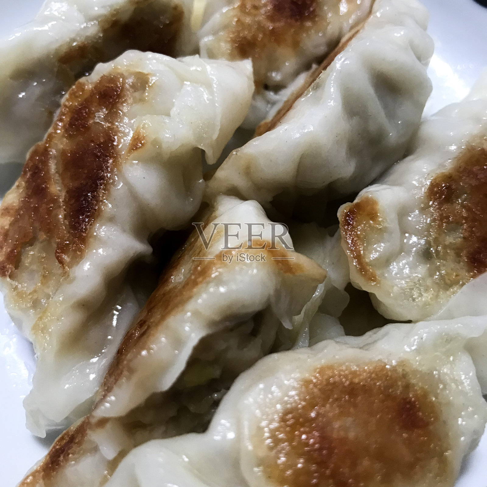 在白色的盘子和白色的背景上拍摄的炸饺子的特写。日本料理概念。照片摄影图片