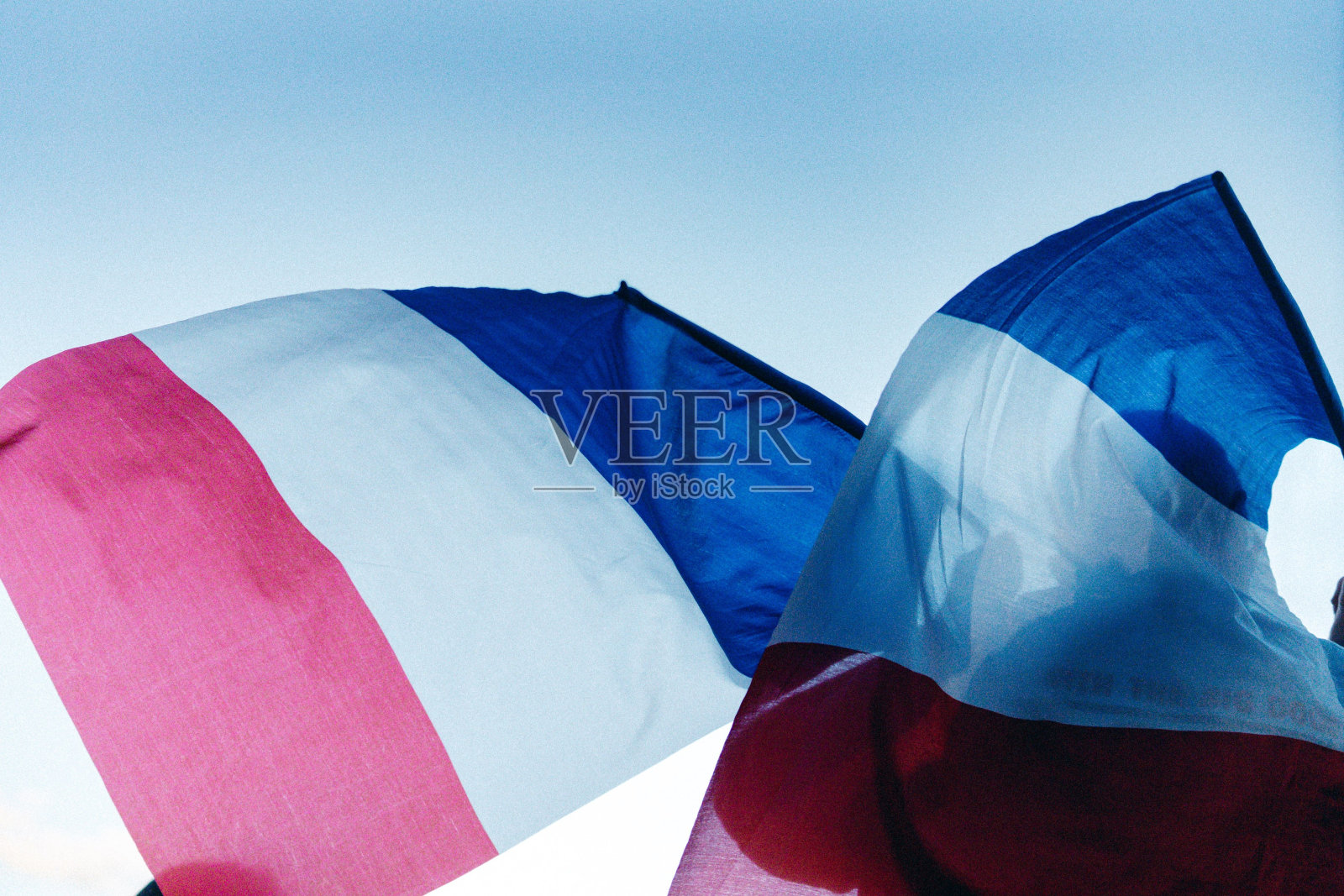 在蓝天的背景下，两面法国国旗随风飘扬。照片摄影图片