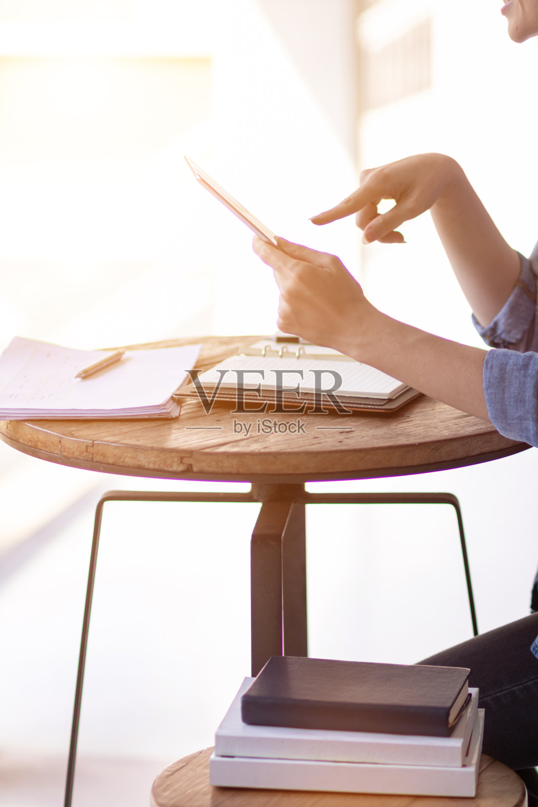 年轻女性在家工作，使用平板电脑搜索信息，与同事交流在线工作。通过在线系统使用平板电脑在家工作的概念。照片摄影图片