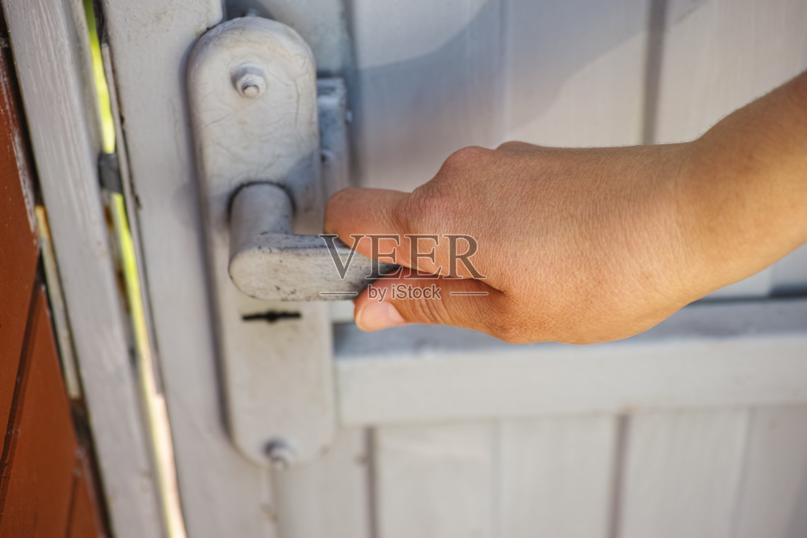 一个女人用门把手打开一扇金属大门照片摄影图片