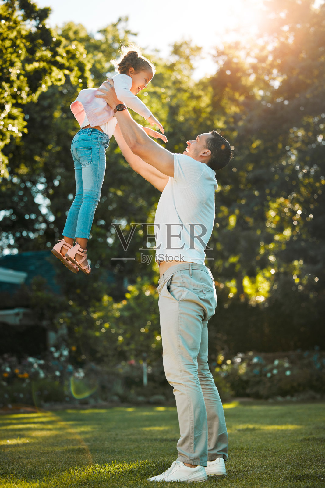 幸福的家庭：年轻的混血父亲和女儿在阳光明媚的后院玩耍照片摄影图片