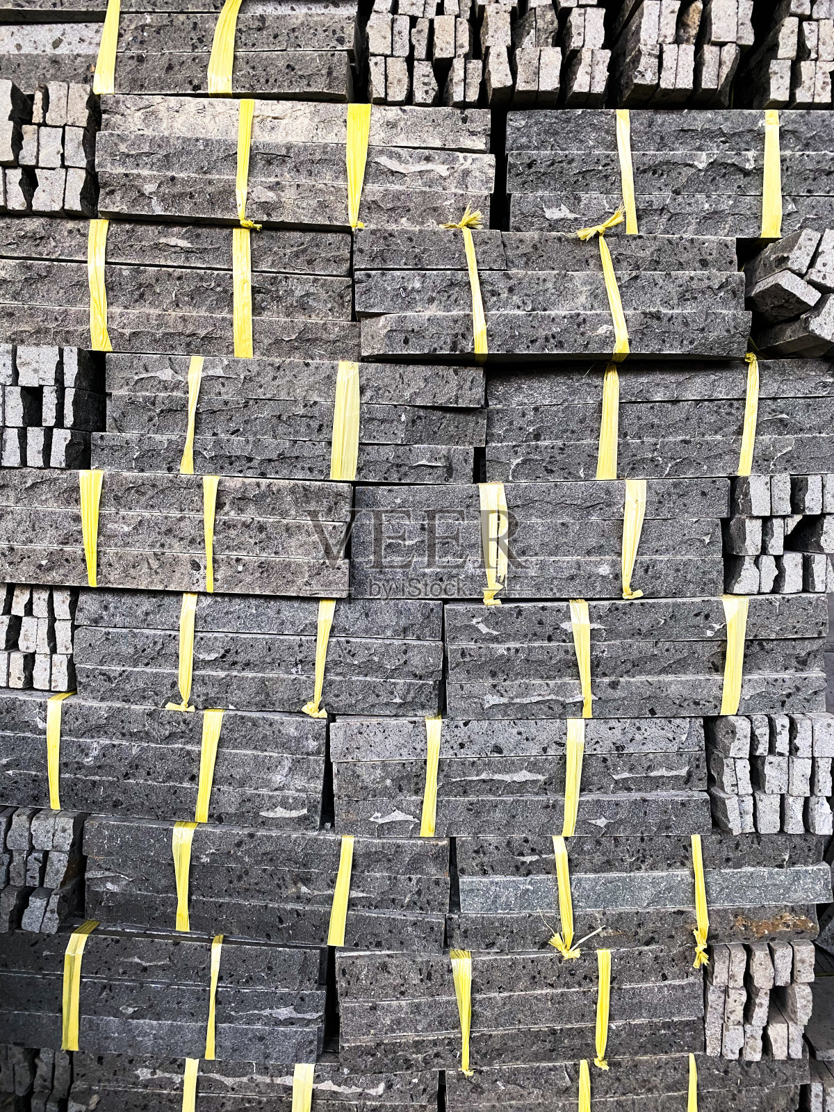 灰色天然石材系黄色塑料领带。墙面建筑材料。照片摄影图片