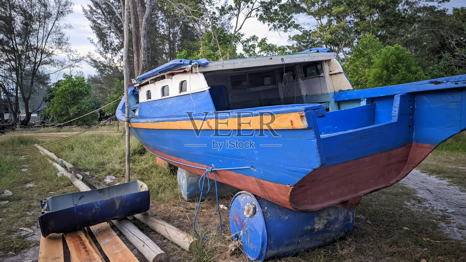 海滩上渔夫的蓝色小船照片摄影图片