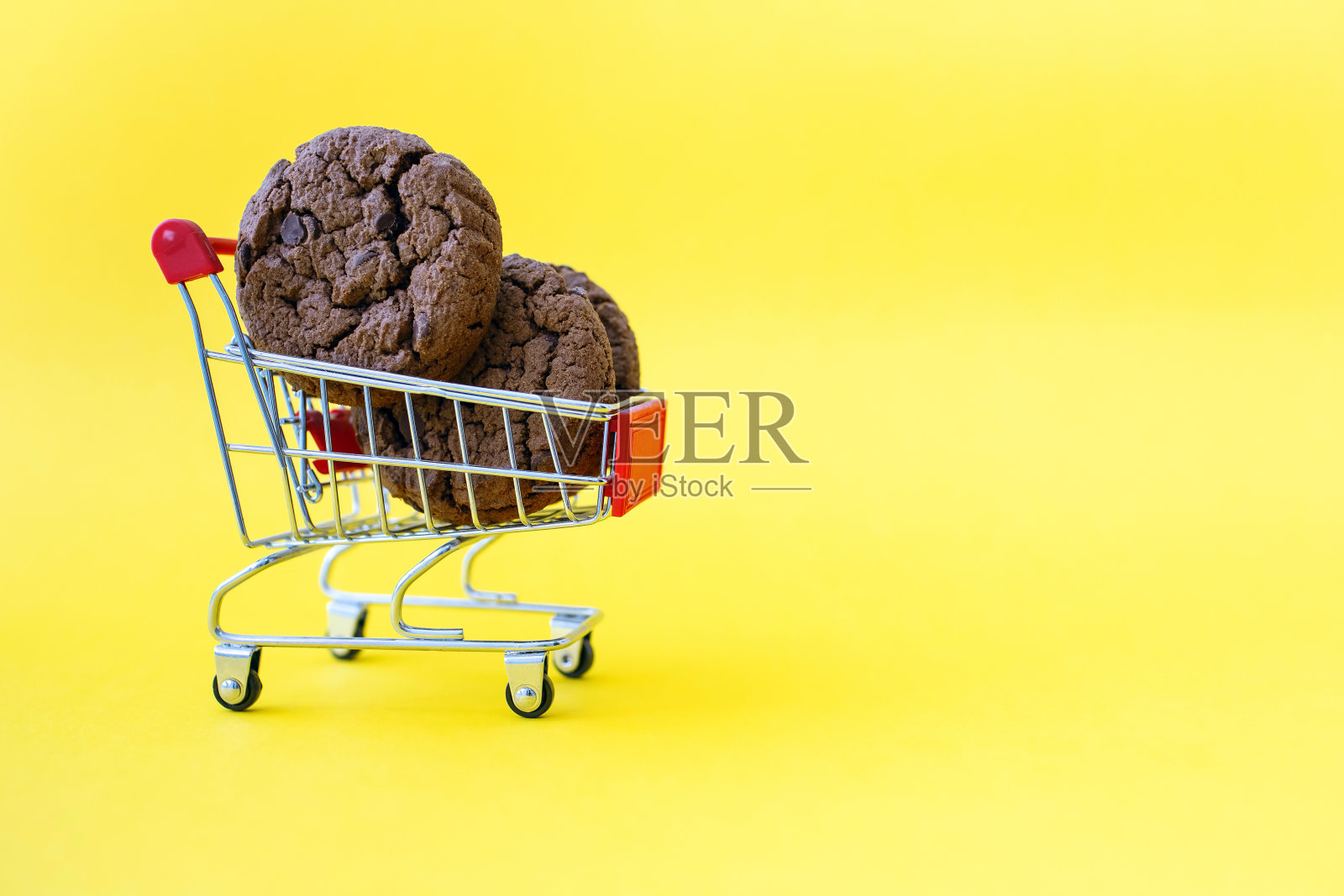 黄色背景的推车里放着巧克力曲奇照片摄影图片
