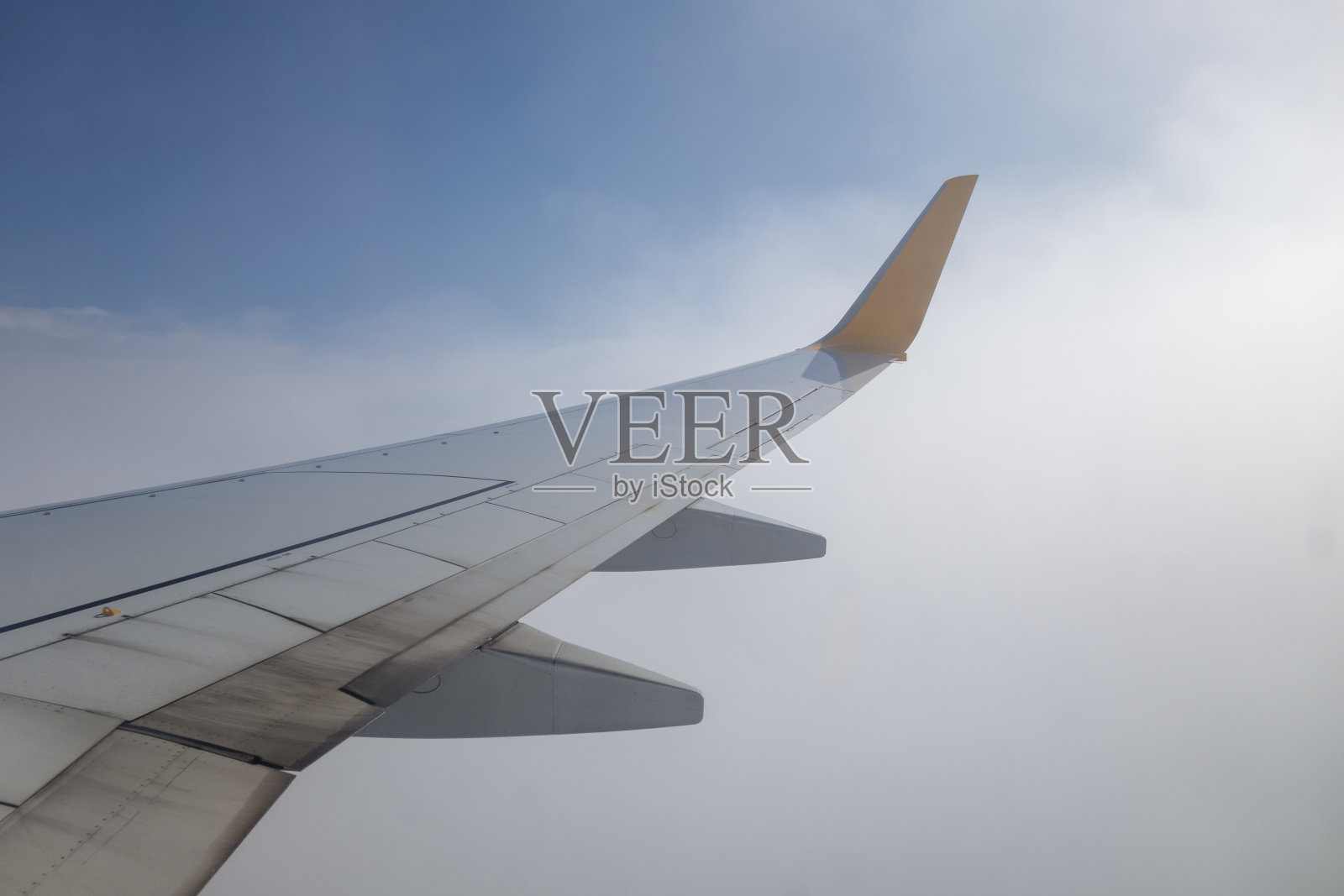 飞机的机翼在天空的云层上飞行照片摄影图片