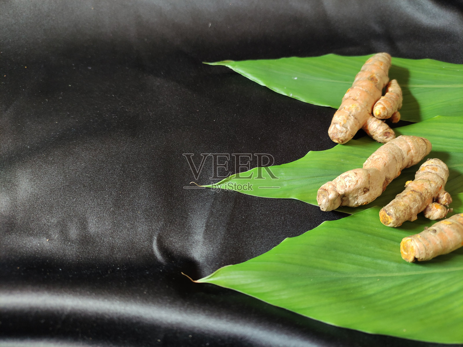 新鲜的姜黄和一些绿叶照片摄影图片